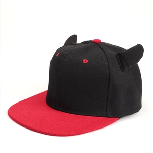 Detail of red flat brim and black devil horns on a stylish camouflage hip-hop hat