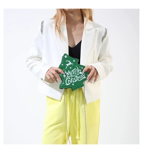 Detail of green Christmas tree shaped crossbody bag with silver chain and festive print