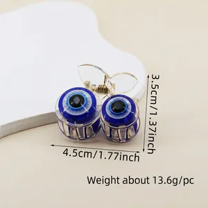 Detailed close-up of small evil eye hair claw clip featuring blue glittery beads