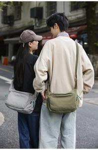 Street view showing grey and green nylon messenger bags with adjustable straps on models