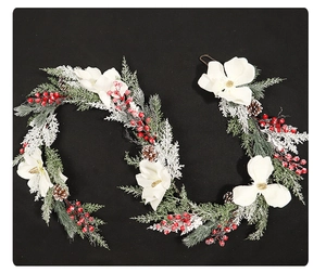 Détail de guirlande de Noël avec magnolias blancs, baies rouges et aiguilles de pin enneigées