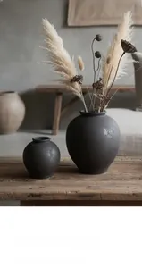 Detalle de jarrones de cerámica negra mate con textura rústica en decoración minimalista wabi-sabi