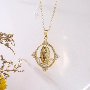 Dettaglio del ciondolo Maria dorato con alone di zirconi e decorazione di fiori secchi