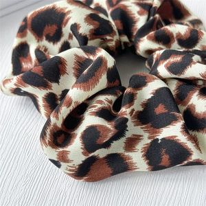 Close-up of leopard print hair scrunchie showing detailed fabric texture and twill pattern