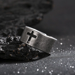 Macro detail of retro hollow cross ring featuring oxidized black finish on volcanic stone