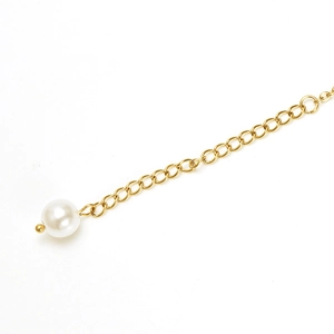 Detail of 18K gold titanium steel anklet featuring a pearl tassel and adjustable extension chain