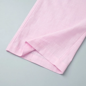 Detailaufnahme der rosa Leinenstruktur und der Doppelnaht am Saum der Hose für Damen