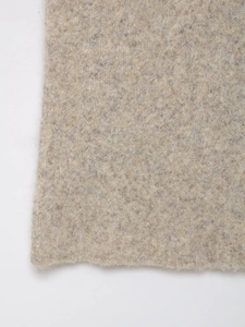 Gros plan sur la texture de la maille chinée beige avec détails de fibres douces