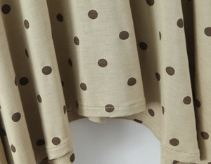 Gros plan détaillé de la texture du tissu à pois kaki avec couture d'ourlet à double aiguille