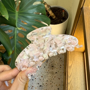 Macro detail of large marble pink acetate hair claw clip with glossy mica texture finish