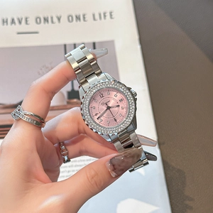 Elegant women's watch with silver steel band, pink dial and rhinestone bezel on wrist