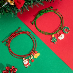 Detailed view of colorful Christmas charms on red and green woven bracelet with festive decor