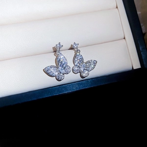 Close-up of sparkling silver butterfly earrings with clear zircons in a jewelry box