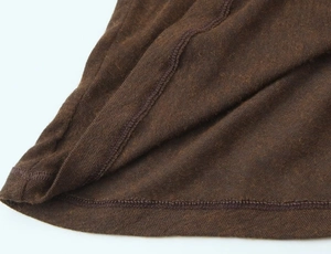 Detailed close-up showing precision stitching and fabric texture of dark brown knit top