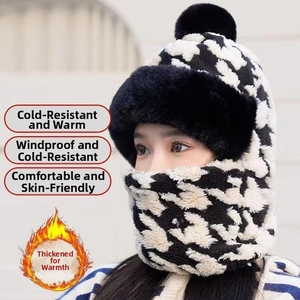 Close-up of winter faux fur bucket hat with black and white houndstooth pattern and pompom