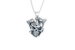 Detailed view of silver skull and cobra pendant with polished metal finish and fine engraving