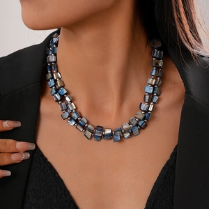Detail shot of a double-layered blue shell-like beaded necklace on a model