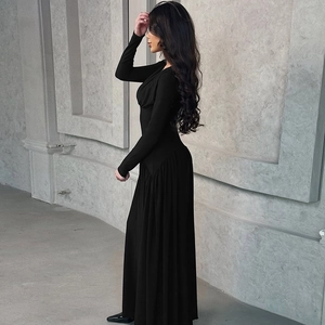 Close-up of elegant black long-sleeve slim fit maxi dress with a flowing drape finish