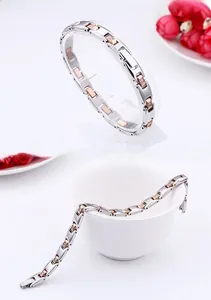 Detail of two-tone stainless steel link bracelet with zircons and fold-over clasp