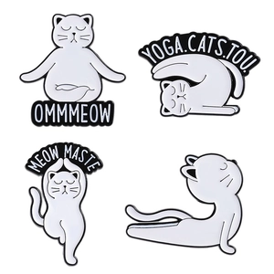 Set of four white cat yoga enamel pins with creative lettering on a plain white background