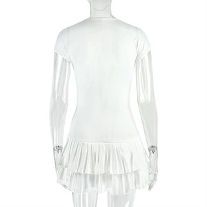Detail of white slim-fit knit mini dress featuring layered ruffle hem and U-neckline