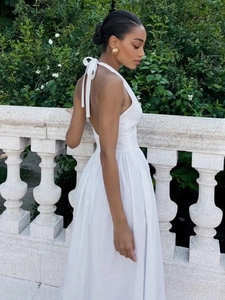 Detail of white cotton halter dress featuring backless tie design and elegant A-line silhouette