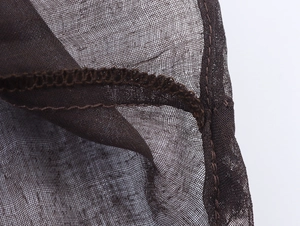 Macro shot of dark brown mesh fabric showing detailed stitching and sheer texture