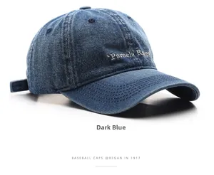 Macro detail of dark blue washed denim baseball cap with white Pamela Rina embroidery