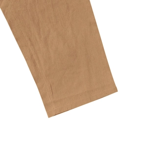 Detailed macro shot of the double-stitched hem on khaki linen blend fabric pants