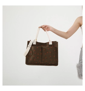 Detail of strawberry print corduroy tote bag showing large pockets and versatile straps