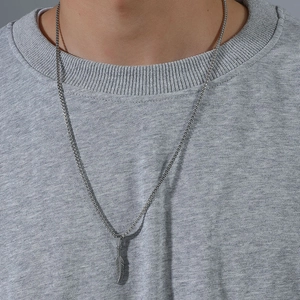 Men's silver stainless steel feather pendant necklace worn by model on grey hoodie