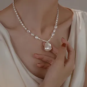 Detailed view of French baroque pearl necklace with oversized drop pendant on model