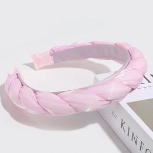 Detail of pink twisted satin headband showing elegant woven texture on book