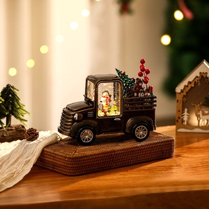 Close-up of vintage bronze Christmas truck with snowman scene and swirling snow