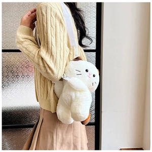 Side view of white plush cat crossbody bag with adjustable strap worn by a model