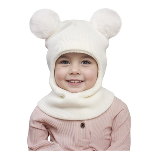 Close-up of white knit baby balaclava with two large soft faux fur pom-poms on top