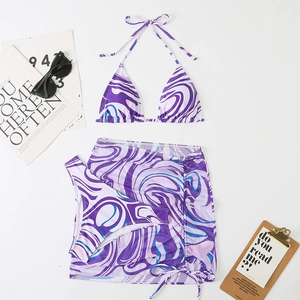 Detailed flat lay of a 3-piece marble print bikini set with sarong and summer accessories