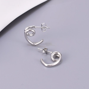 Gros plan de boucles d'oreilles spirale géométrique argentée avec fermoir papillon