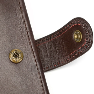 Macro shot of dark brown genuine leather wallet with vintage brass star snap button