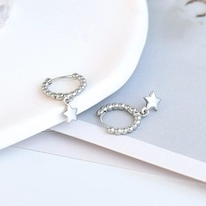 Close-up of S925 sterling silver hoop earrings featuring a polished star pendant