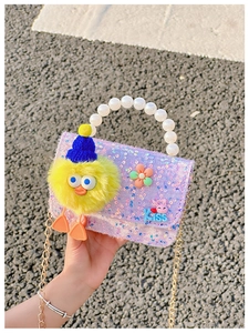 Detail of girls' purple sequin bag with pearl handle, gold chain, and cute plush charms
