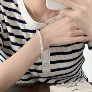 Close-up of a 925 sterling silver woven geometric bracelet on a model's wrist