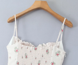 Detailed view of floral slip dress with ruffled neckline and smocked bodice texture