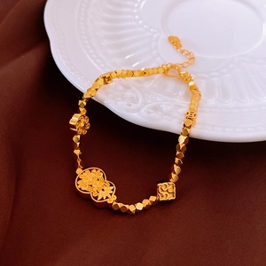 Close-up of gold-plated flower and gourd bracelet on elegant white relief porcelain