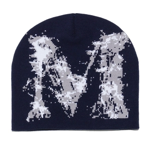 Gros plan sur la texture en tricot et le motif jacquard de lettre sur le bonnet bleu