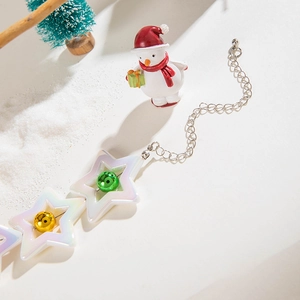 Macro shot of iridescent star-shaped necklace links with colorful beads and snowman decor