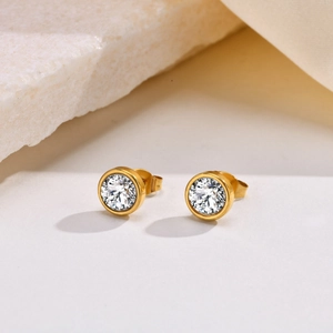 Detailed close-up of gold bezel-set cubic zirconia stud earrings with secure butterfly backs