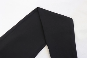 Close-up detail of high-elastic black fabric texture and stitching on the slim jumpsuit