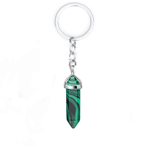 Detail of silver hex column keychain with green malachite pendant on white background