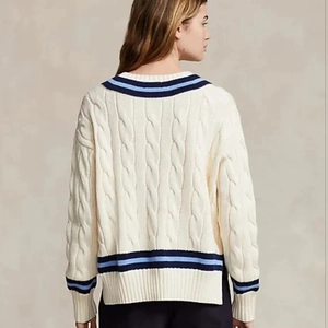 Close-up of the back view of a cable knit sweater featuring navy and light blue stripes